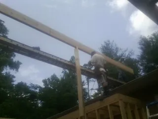 Carpenter setting a ridge beam over a new addition frame — Ice Dam Removal by Roofing Brothers in Melba