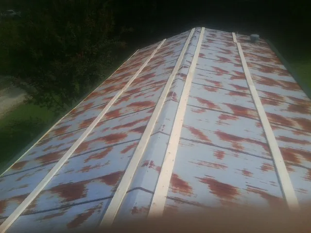 Rusted metal roof panels with new wood purlins before replacement — Storm Damage Roof Repair in Melba by Roofing Brothers