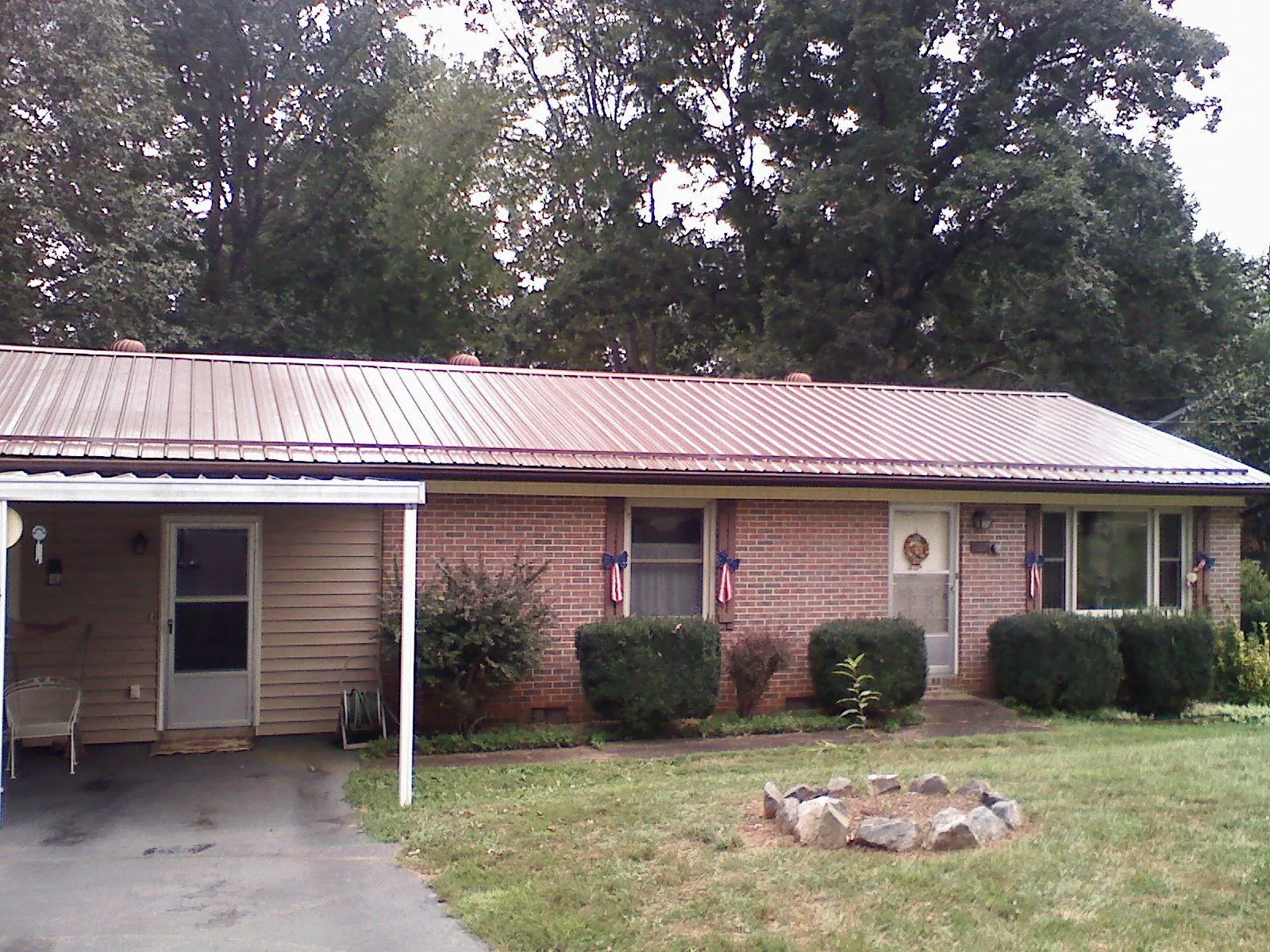 Bronze metal roof and carport on a brick ranch home — Roof Repair work by our crew in Melba