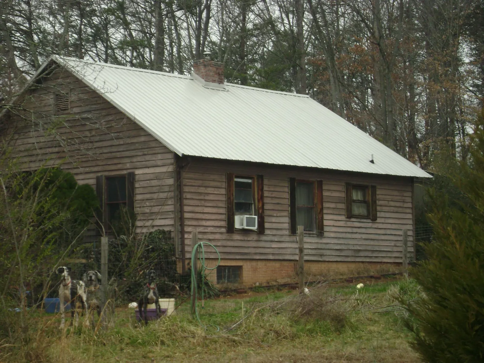 White metal roof on an old wood sided farmhouse, from a Metal Roof Installation job in Melba